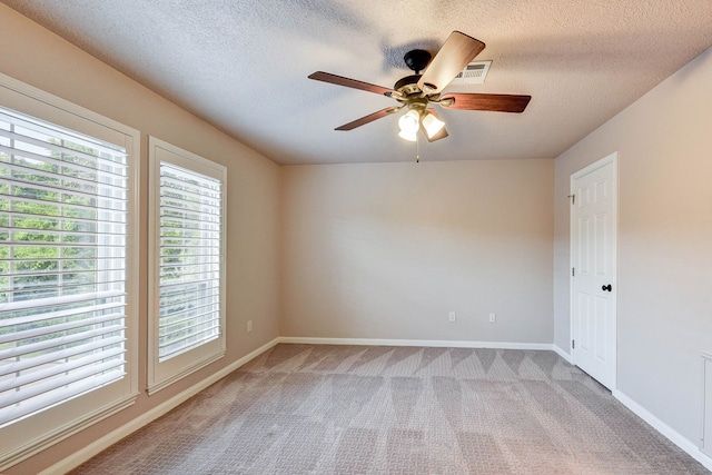 carpeted spare room with ceiling fan and a textured ceiling