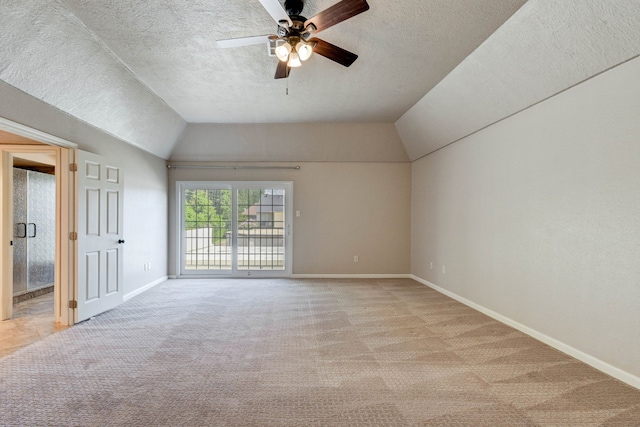 interior space with vaulted ceiling, a textured ceiling, and ceiling fan