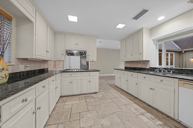 kitchen with backsplash, dark stone counters, stainless steel gas cooktop, dishwasher, and white cabinetry