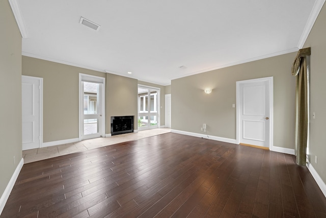 unfurnished living room featuring crown molding and dark wood-type flooring