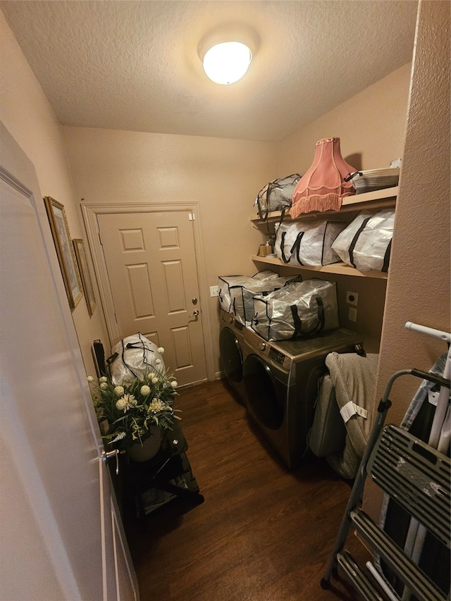 laundry area with dark wood-type flooring, washing machine and dryer, and a textured ceiling