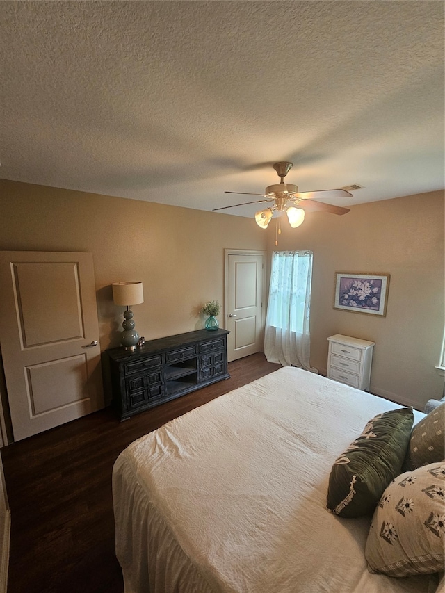 bedroom featuring a textured ceiling, dark hardwood / wood-style flooring, and ceiling fan