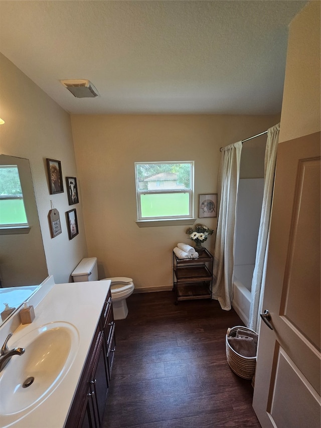 full bathroom with toilet, vanity, hardwood / wood-style floors, and plenty of natural light