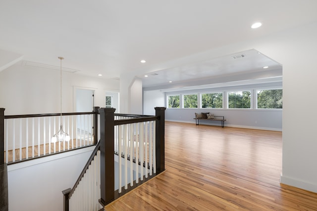 hall featuring light hardwood / wood-style flooring and an inviting chandelier