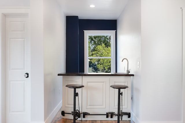 bar with sink and light wood-type flooring