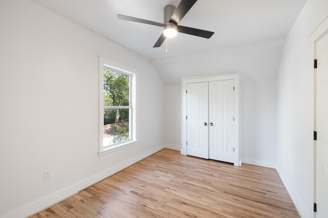 unfurnished bedroom featuring lofted ceiling, light hardwood / wood-style flooring, a closet, and ceiling fan