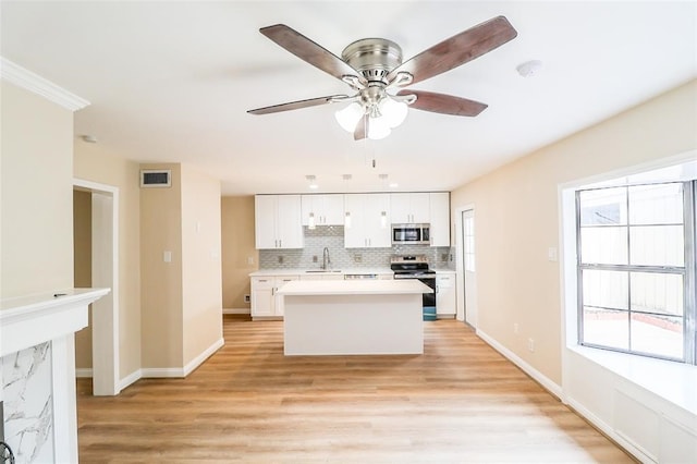 kitchen with white cabinetry, stainless steel appliances, sink, and plenty of natural light