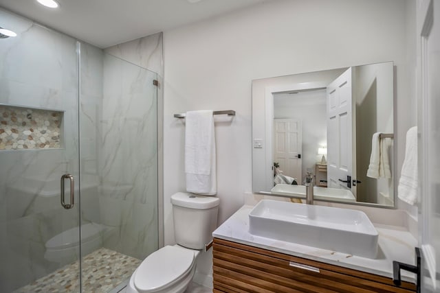 bathroom featuring vanity, toilet, and a shower with door