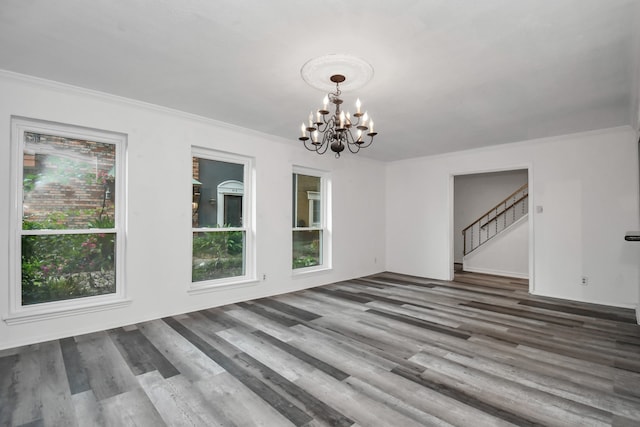 unfurnished dining area featuring a chandelier, dark hardwood / wood-style floors, and ornamental molding