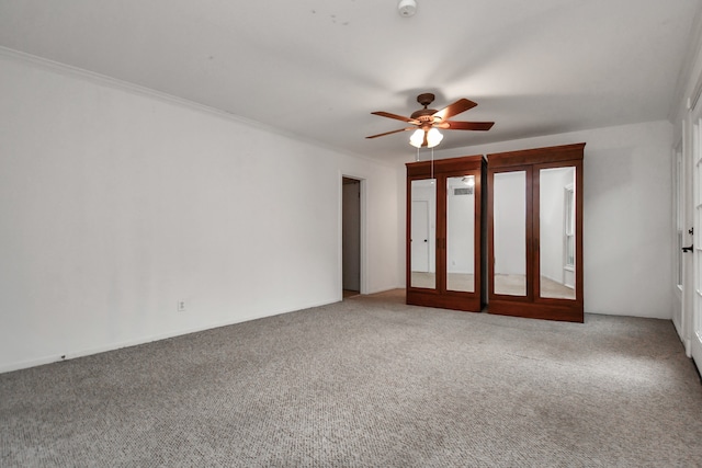 carpeted spare room with ceiling fan, crown molding, and french doors