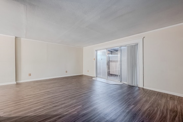 spare room featuring dark wood-type flooring and a textured ceiling