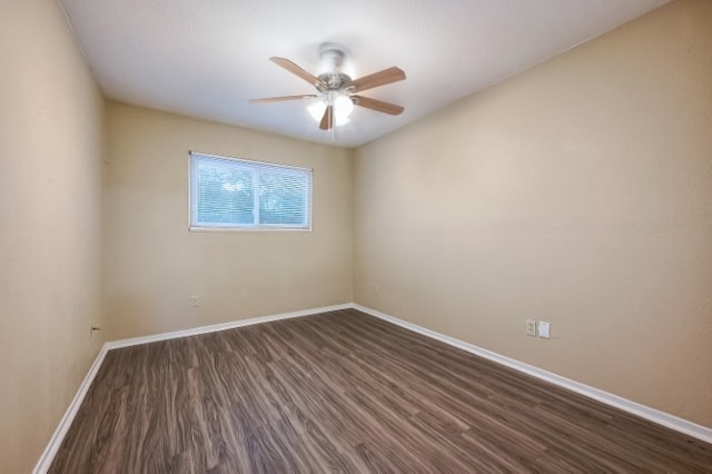 spare room featuring dark hardwood / wood-style flooring and ceiling fan