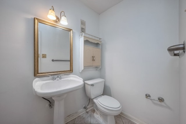 bathroom with toilet and tile patterned flooring