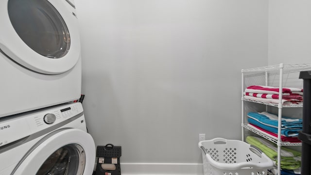 washroom featuring stacked washer and clothes dryer