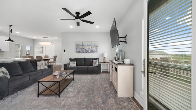 living room featuring dark wood-type flooring and ceiling fan