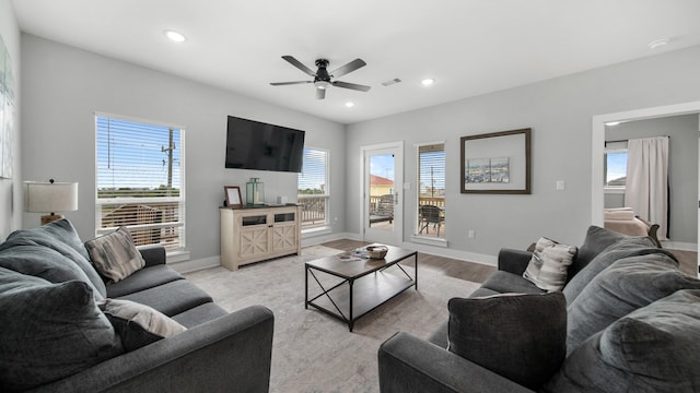 living room with light hardwood / wood-style flooring, a healthy amount of sunlight, and ceiling fan