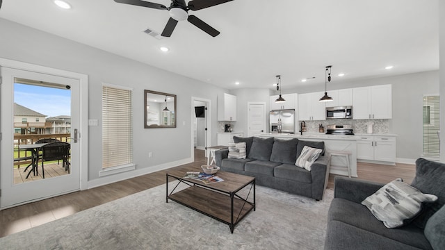 living room with light wood-type flooring and ceiling fan