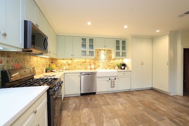 kitchen with light wood-type flooring, white cabinets, sink, and stainless steel appliances