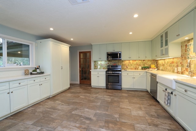 kitchen featuring stainless steel appliances, sink, and tasteful backsplash