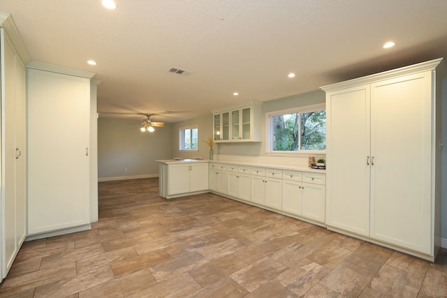 kitchen featuring white cabinets, kitchen peninsula, and ceiling fan