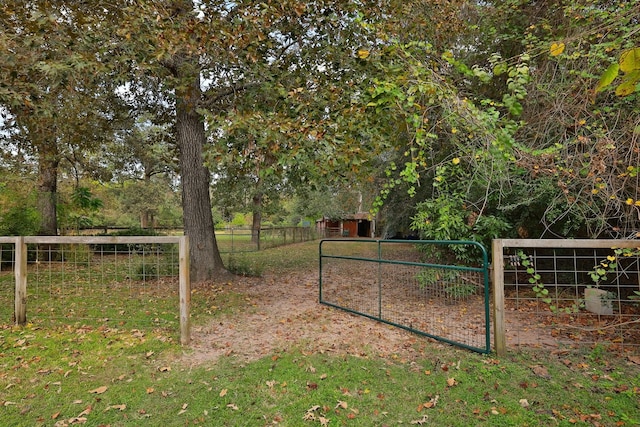 view of gate with a lawn