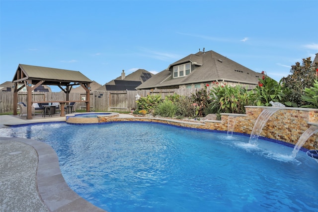 view of swimming pool featuring a gazebo, a patio area, pool water feature, and an in ground hot tub