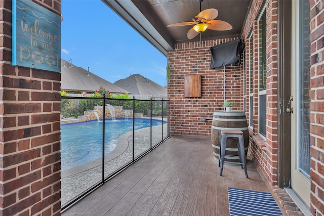 view of swimming pool featuring ceiling fan and pool water feature