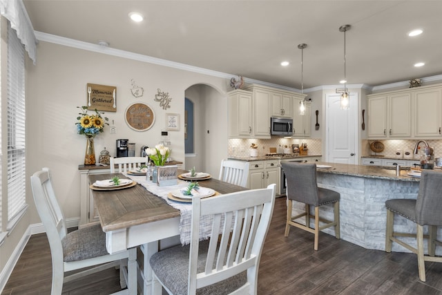 dining space with crown molding, dark hardwood / wood-style floors, and ceiling fan