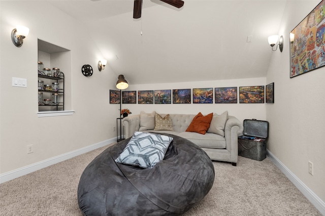 living area with ceiling fan, vaulted ceiling, and light colored carpet