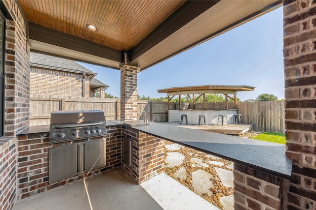 view of patio / terrace featuring a gazebo, exterior kitchen, and a grill