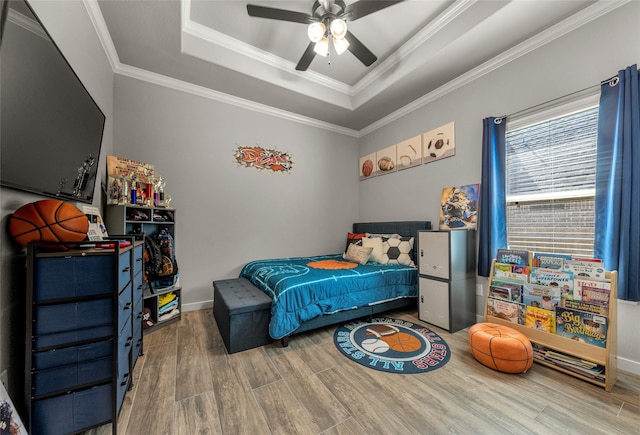 bedroom with hardwood / wood-style floors, a raised ceiling, crown molding, and ceiling fan