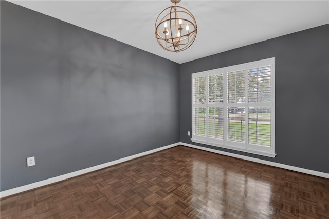 empty room with dark parquet flooring and a chandelier