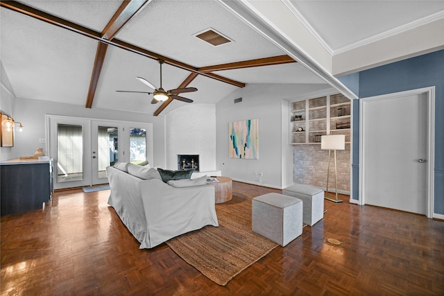 living room with ceiling fan, a fireplace, lofted ceiling with beams, dark parquet floors, and french doors