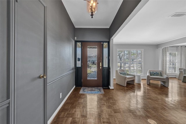 entrance foyer with decorative columns, crown molding, and dark parquet floors