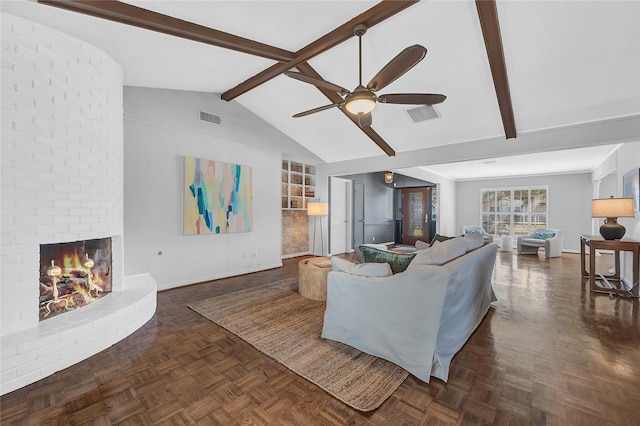 living room featuring vaulted ceiling with beams, built in features, dark parquet floors, ceiling fan, and a fireplace