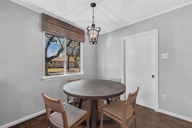 dining area featuring crown molding, dark parquet flooring, and a chandelier