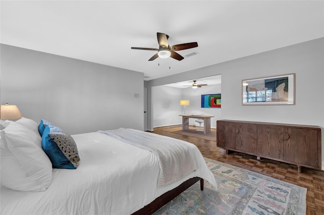 bedroom with ceiling fan and dark parquet floors