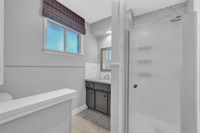 bathroom featuring tasteful backsplash, vanity, and a shower with door