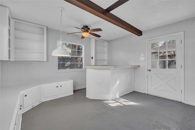 interior space featuring hanging light fixtures, white cabinetry, plenty of natural light, and a textured ceiling