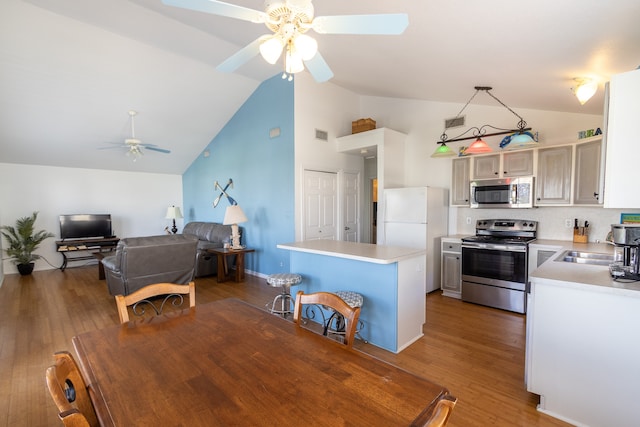 kitchen featuring hanging light fixtures, backsplash, dark hardwood / wood-style flooring, appliances with stainless steel finishes, and ceiling fan