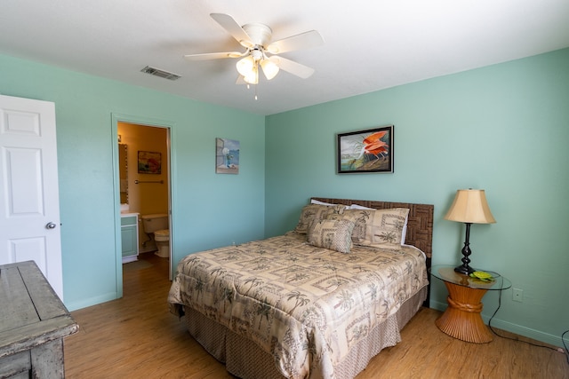 bedroom featuring light hardwood / wood-style flooring, ensuite bathroom, and ceiling fan