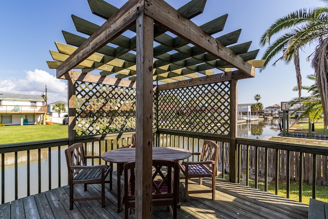 wooden deck featuring a yard, a water view, and a pergola