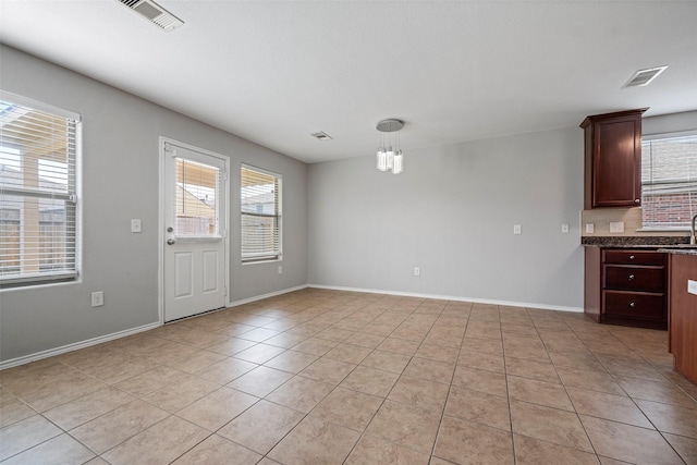 interior space featuring a healthy amount of sunlight, visible vents, baseboards, and light tile patterned floors