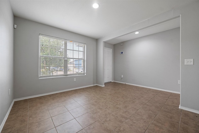 empty room with recessed lighting, baseboards, and light tile patterned floors