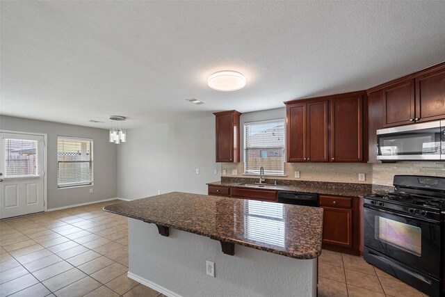 kitchen with light tile patterned floors, sink, a center island, and black appliances