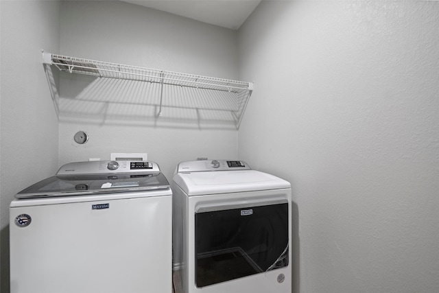 clothes washing area with separate washer and dryer