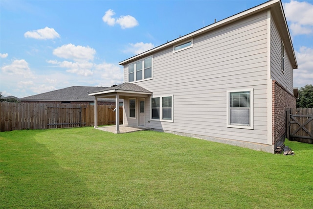 rear view of house featuring a yard, brick siding, a patio area, and a fenced backyard