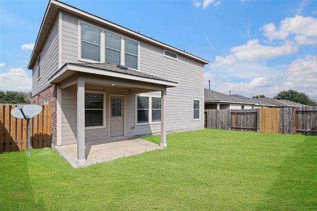 rear view of property featuring a patio area, a lawn, a fenced backyard, and brick siding