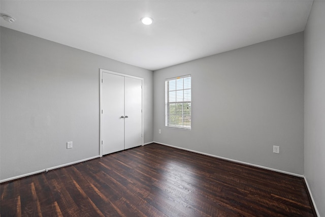 unfurnished bedroom featuring a closet and dark hardwood / wood-style floors