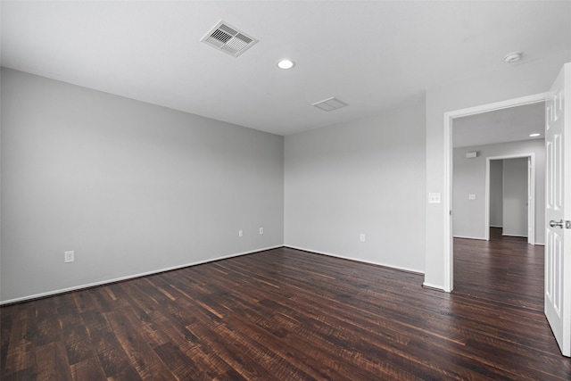 spare room featuring dark wood-style floors, visible vents, and recessed lighting